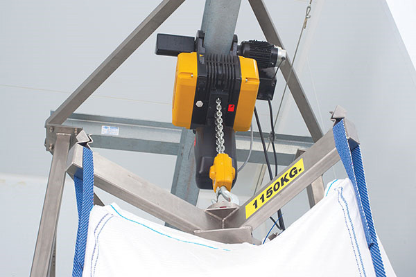 Electric hoist raises the lifting frame and bulk bag, which are rolled into position by a trolley.